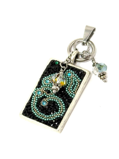Experience the elegance of tiny turquoise pearls and crystals encircled by striking black glass crystals in a captivating circular design.