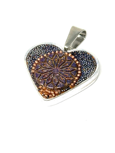 Introducing a stunning slide-on mosaic heart pendant, intricately hand-beaded in vibrant shades of orange and purple. This unique accessory adds a touch of elegance and individuality to any outfit.