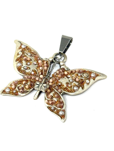 Close-up of a handmade Rhodochrosite and Butterfly interchangeable pendant necklace.