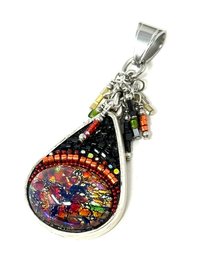 Handmade teardrop pendant featuring a black opal shimmer focal bead, set in an antique pewter bezel with intricate multicolored seed bead detailing on a white background.
