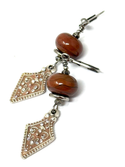 Unique Handmade Lampwork Glass Earrings accented with a filigree dangling bead. Beautiful rust color is so different.