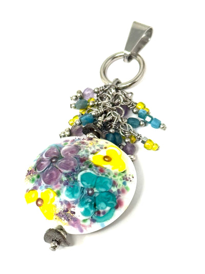 Beautiful floral lampwork glass focal bead with cascading hand-wired beads dangling above.