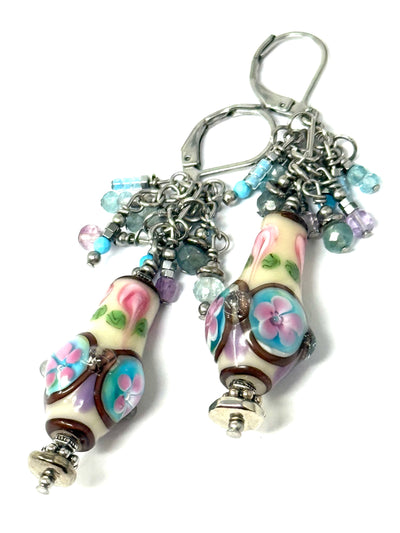 Beautiful pastel colored floral lampwork glass beads with dangling gemstones.