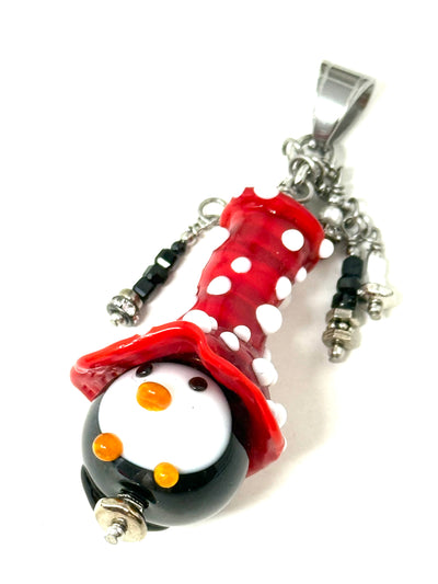 Handmade lampwork glass penguin pendant with red Santa hat, seed beads, bugle beads, and pearl accents in ornate beaded bezel - front view