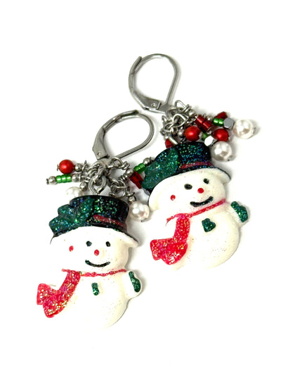Handmade Christmas snowman earrings with frosted shimmer snowman beads and cascading red, green, and white pearls - front view on white background
