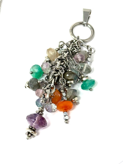 A colorful faceted gemstone dangly cluster pendant in vibrant shades of green, orange, yellow, and purple. 